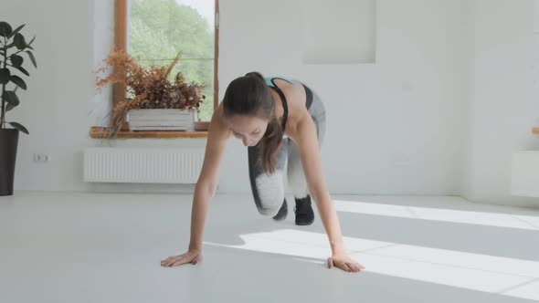 Young Attractive Fit Girl in Sportswear Running Plank in Bright Room at Home