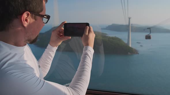 Tourist is Filming By Smartphone Moving Cabin of Cable Car in Phu Quoc alt