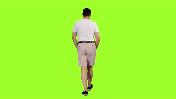 Rear View of Man Tourist Walks with Hands in Pockets