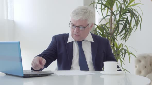 Angry Strict Businessman Scolding Employees in Wireless Chat. Portrait of Dissatisfied Senior alt