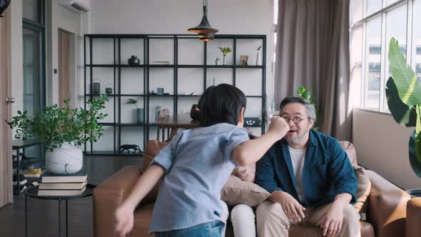 Asian boy was dancing in the living room with his parents cheering.