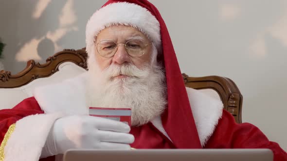 Santa Claus copying his credit card numbers when buying gifts on the internet.