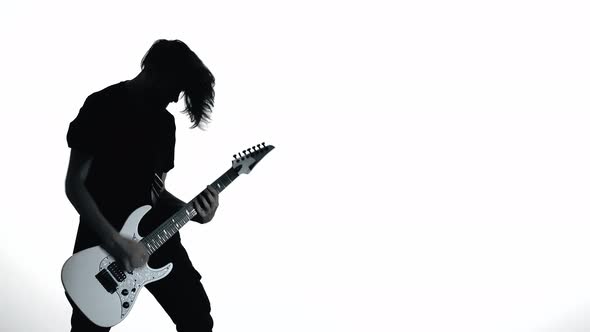 Silhouette of Guitarist Playing Electric Guitar