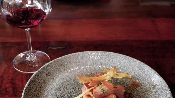 Tilt down from red wine to smoked duck breast with king oyster mushroom chips alt