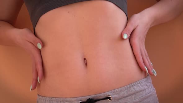 Girl With a Beautiful Figure Measures Her Waist with a Measuring Tape alt