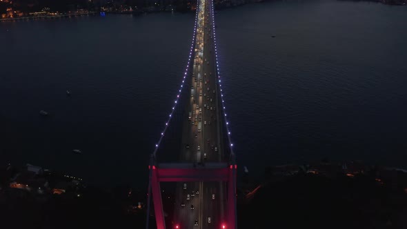 Beautiful Red Bridge Over Bosphorus in Red Light at Night with Car Traffic, Aerial Birds Eye View alt