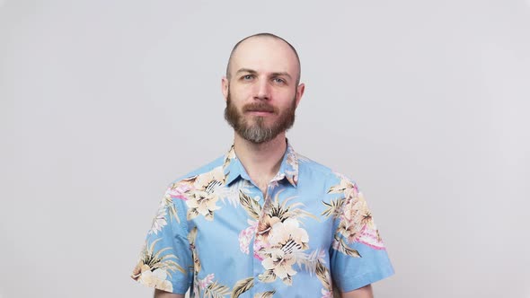 Portrait of calm bearded man looking at camera wearing hawaiian shirt