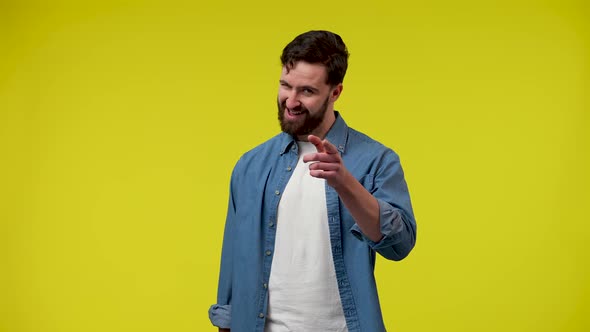 Portrait of a Man Flirting Winking Pointing with His Index Finger Hey you alt