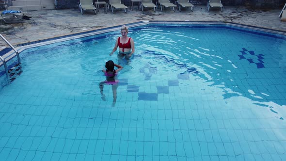 Mother and Daughter Playing in a Swimming Pool