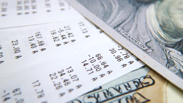 Macro Tracking Shot of Hundred Dollar Bills and Receipts From Supermarket alt