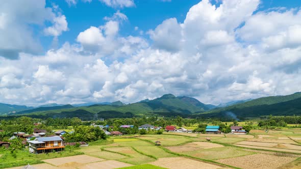 Beautiful rice paddy farming filed and village town at Pua district, Nan, Thailand - time lapse