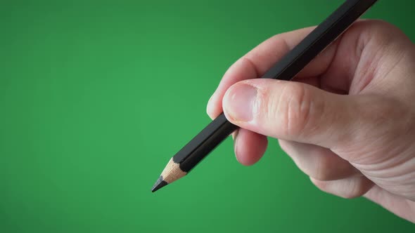Man Holding Pencil In His Hand Isolated On Chroma Key Green Screen Background alt
