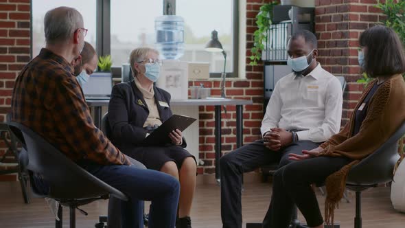 Therapist Giving Advice to Multi Ethnic Group of People with Face Mask at Aa Meeting alt