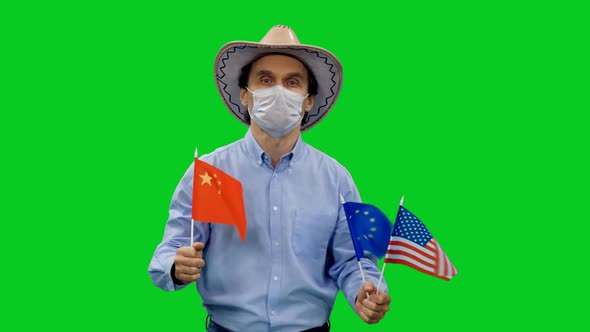 Adult Man in Protective Mask and Cowboy Hat Walks with Waving Flags of China, EU and USA 