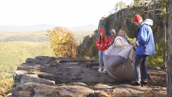 Young Group of Tourists Groaning a Tent on a Mountain Top
