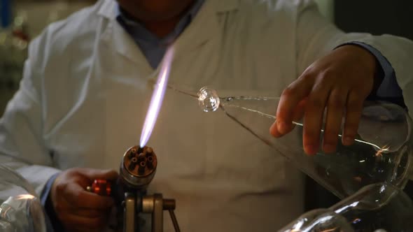 Front view of mature Indian male worker making wing glass in glass factory 4k alt