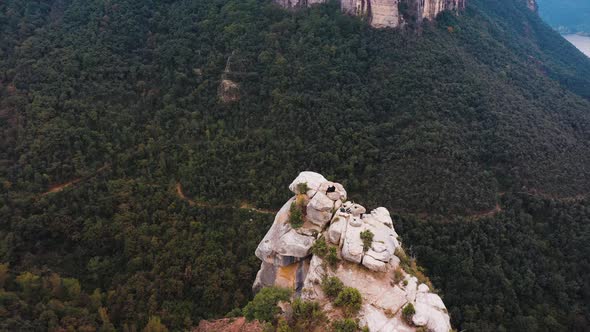 The cliff of Tavertet, Spain. There are two people sitting on the edge enjoying the beautiful view. alt