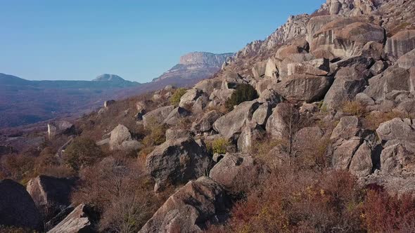 Fly Over Rocky Outcrop in Autumn Mountains alt