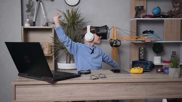 Cool Joyful Modern 7-Aged Boy Dancing at Home Using Virtual Reality Headset alt