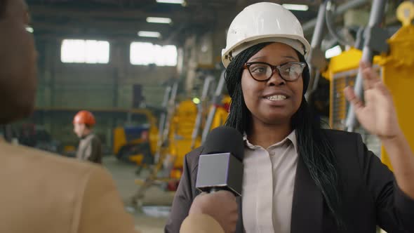Female Factory Manager Giving Interview to TV Journalist alt