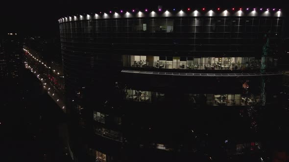 Aerial View From Drone on Glass Facade of Modern Skyscraper with Offices at Night alt