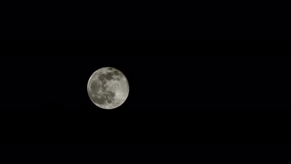 The Full Moon Moves Against the Black Night Sky