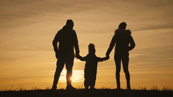 Happy Young Family Together with Their Little Child at Sunset alt