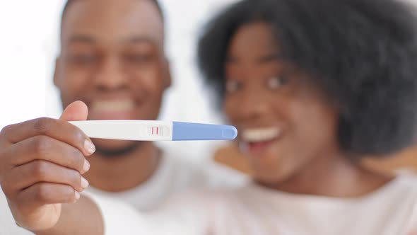 Excited African Married Couple Showing Positive Result of Pregnancy Test Looking at Camera Happy alt
