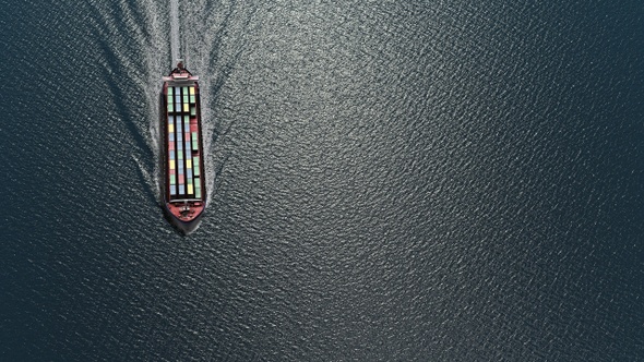 Large cargo ship carrying containers in the sea- Aerial alt