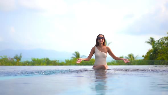 Young asian woman enjoy around outdoor swimming pool for leisure alt