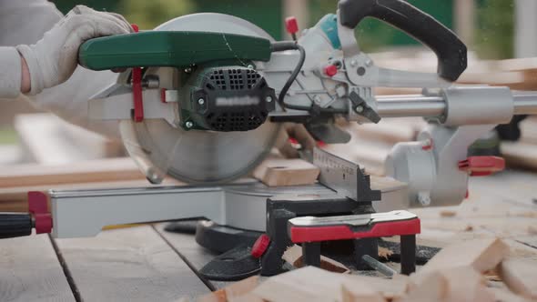 Close Up Shot of Man Cutting Wood Using Table Saw on Construction Site alt