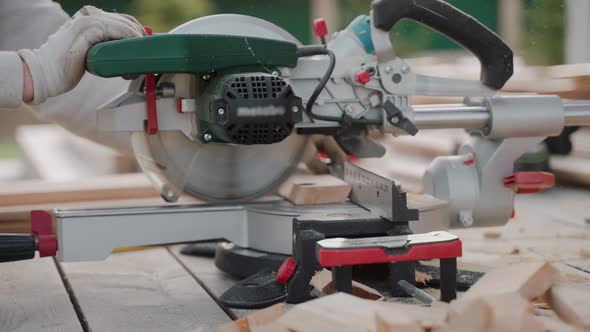 Close Up Shot of Man Cutting Wood Using Table Saw on Construction Site