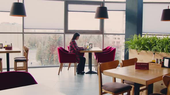 Woman Freelancer Is Working Remotely From Cafe