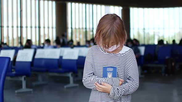 Sad Ukrainian Child Refugee at the Airport with a Passport in His Hands alt
