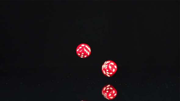 Two red cube falls on a black table