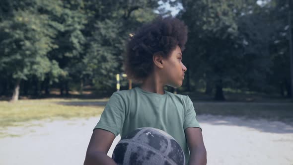 Sad Afro-American Boy With Football at Pitch, No Friends, Racial Discrimination