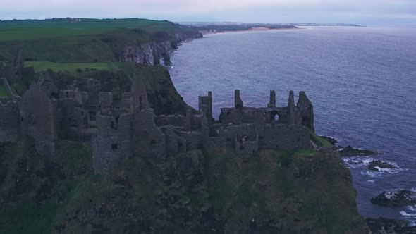 Dunluce Castle on the Antrim Coast, Northern Ireland. Aerial drone pull away alt