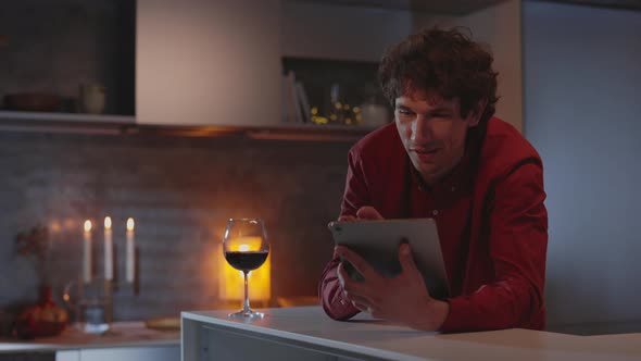 Man Using Tablet and Drinking Wine During Evening Time alt