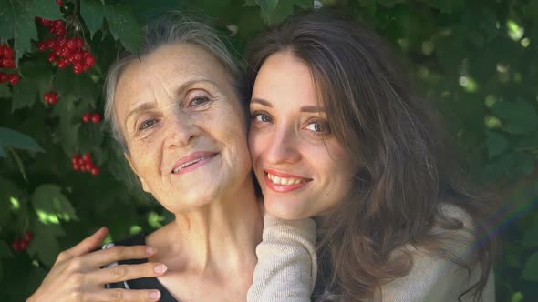 Happy Senior Mother in Eyeglasses is Hugging Her Adult Daughter the Women are Enjoying Together alt