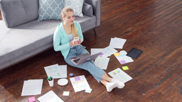 Young woman works with documents using a laptop at home. alt
