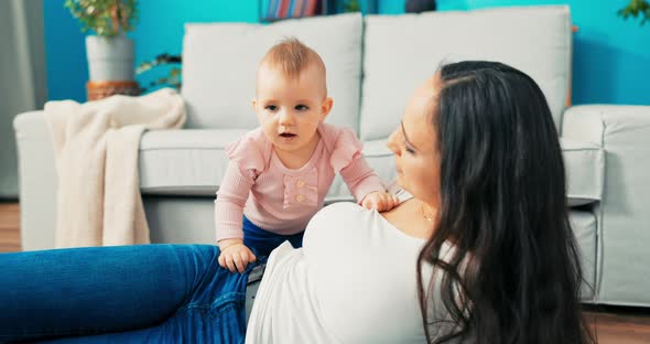 Attractive Mature Mom with Long Brown Hair is Lying on Living Room Floor Talking to alt