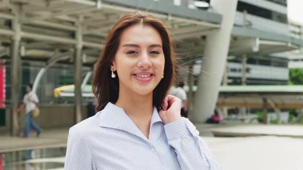 Portrait of Asian young smart business woman working in company office in city and look at camera. alt