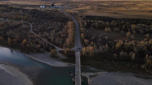 Aerial footage of an old truss bridge over old man river in Alberta, Canada during autumn. Dark fore alt
