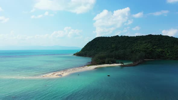 Aerial view of small uninhabited cay with preserved natural exotic forest on sunny summer day. Tropi alt