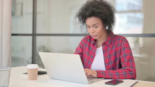 African Woman Celebrating Success While Using Laptop alt