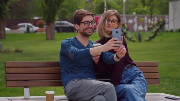 Two friends with glasses take selfie with phone alt