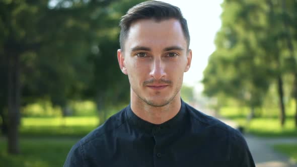 Young Man Walking on the Street and Looking at Camera alt