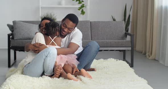 Young Parents Beautiful Woman Mom and Attractive Man Dad in White Casual Clothes Sitting at Home in alt