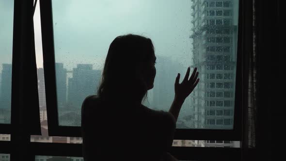 Silhouette Sad Loneliness Woman Touch Glass Window at Rain Day