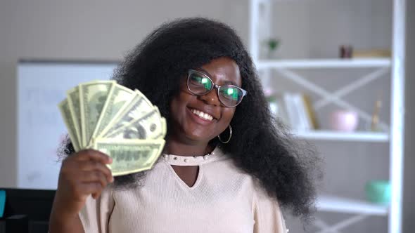 Portrait of Happy Wealthy African American Young Woman Smiling Boasting Cash Money Indoors alt